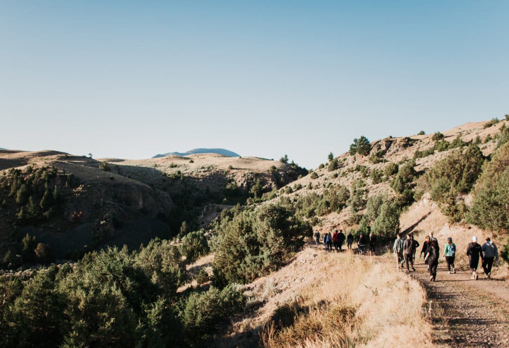 Hikers walking down road through grassy plains around the Mountain Sky Guest Ranch property