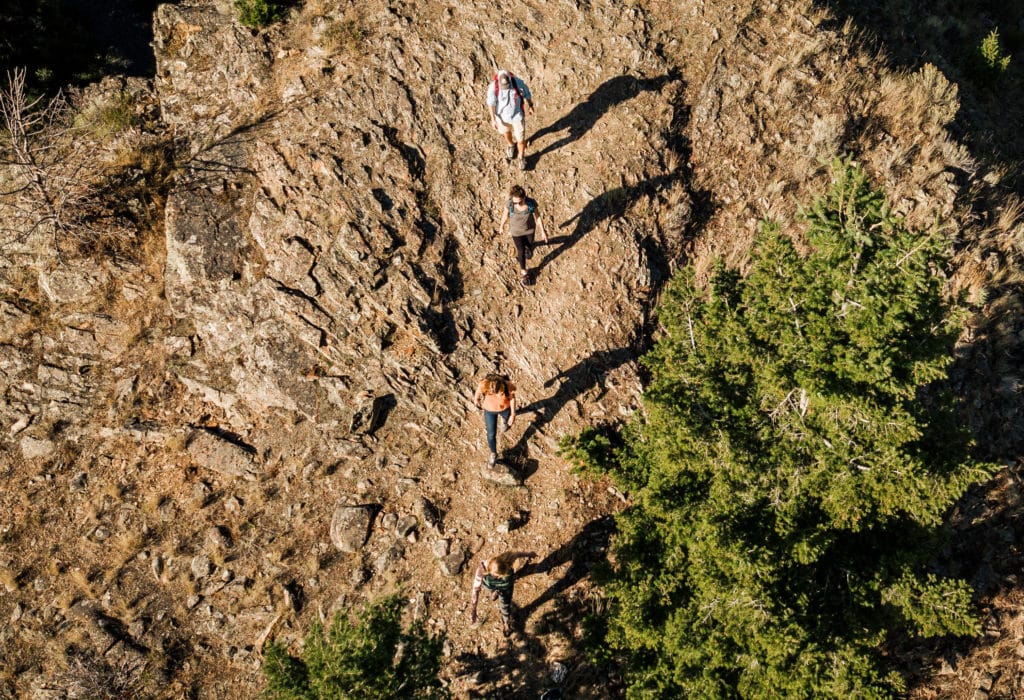 Drone view of hikers walking across a rock face near Mountain Sky Guest Ranch