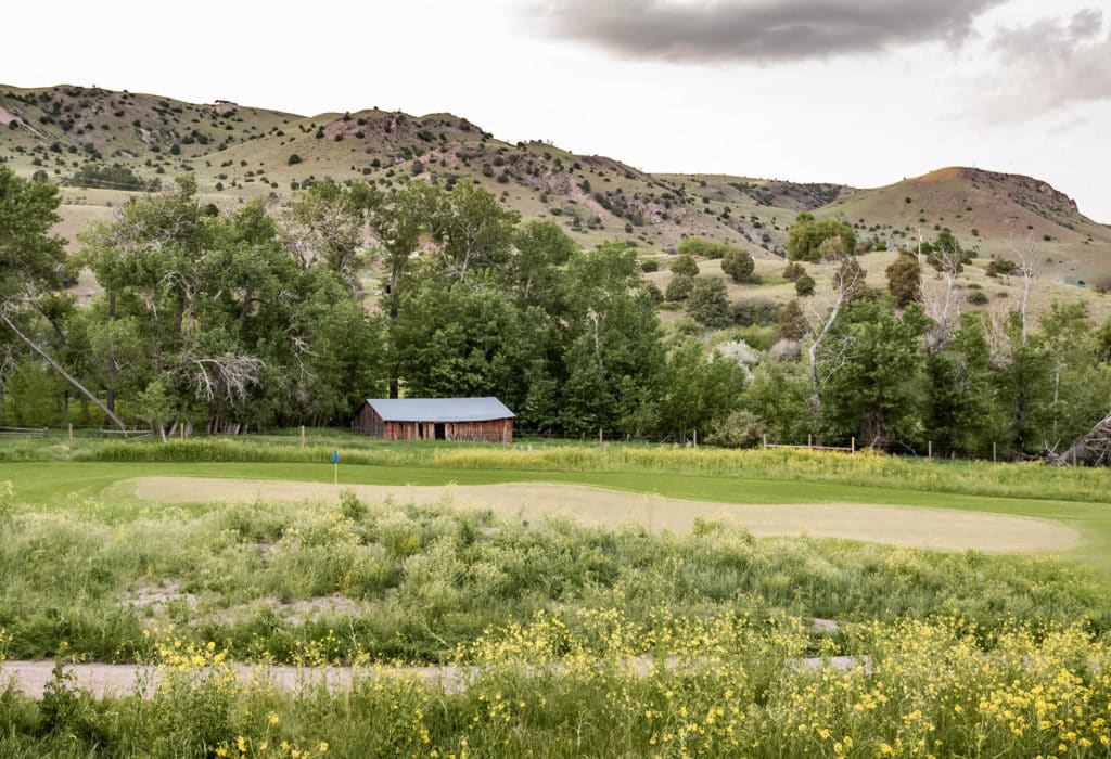 Hole 14 on the Rising Sun Golf Course at Mountain Sky, with visible sand trap and property building in background