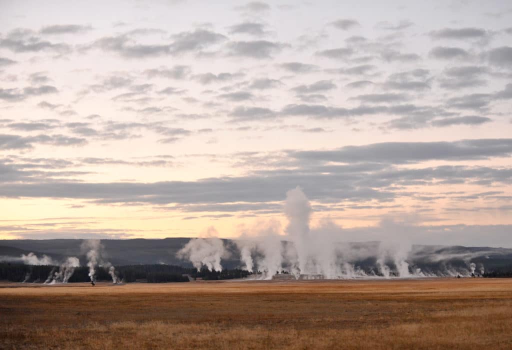 Geysers at Yellowstone over a sunset skyline